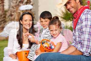 Trick-or-treating as a family. Cropped shot of a family out the treats theyve collected on Halloween.