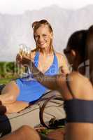 Cheers. Cropped image of two women in swimsuits drinking alcoholic beverages.