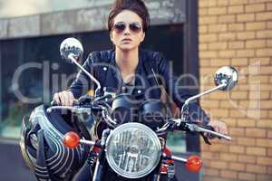 Motorcycle style. Shot of a young and stylish female motorcycle rider outside.