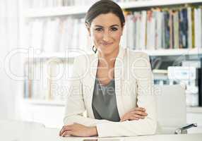 Shes the very meaning of success. Portrait of a young businesswoman sitting at her desk in an office.