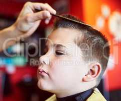 Looking good. Closeup shot of a young boy getting a haircut at a barber shop.