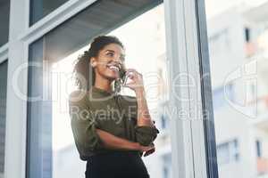 Exciting prospects on the horizon. Shot of a young businesswoman making a phone call in her office.