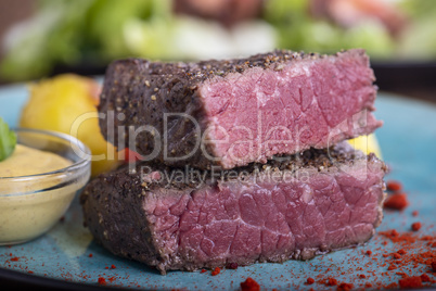 Steakscheiben auf blauem Teller