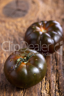 schwarze Tomaten auf dunklem Holz