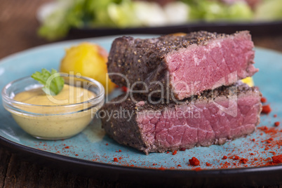 Steakscheiben auf blauem Teller