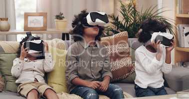 Some virtual fun to keep the boys busy. Shot of three little boys watching movies together through virtual reality headsets at home.