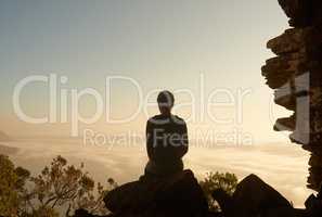 Solitude at sundown. Shot of a woman admiring the view from a mountain top.