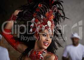 Turning beats into heat. Shot of a beautiful samba dancer performing in a carnival with her band.