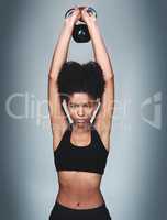 Be determined to reach your goals. Studio shot of a fit young woman posing with a kettle bell against a grey background.