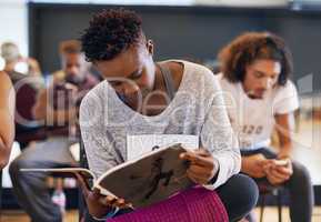 Immersed in a dancing mag. Shot of a young female dancer reading a dancing magazine while waiting for her audition.