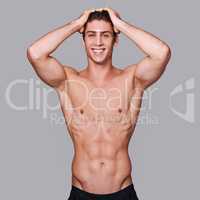 Full body perfection. Studio shot of a handsome bare chested young man grooming.