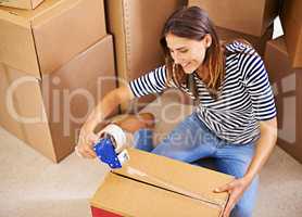 Lets get moving. Shot of an attractive young woman busy moving house.