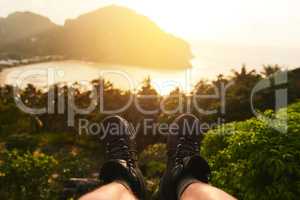 Looking out over paradise. Point of view shot of an unidentifiable tourists feet as he admires an island view.