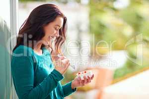 Making the choice to eat healthy every morning. Shot of a young woman eating a healthy snack at home.