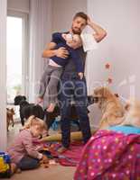 This is too much. An overwhelmed dad surrounded by his kids and dogs.
