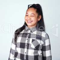 Nudge nudge, wink wink. Studio portrait of a cute and confident young girl posing against a gray background.