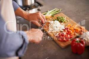 Variety is the spice of life. Cropped shot of a man chopping vegetables on a countertop.