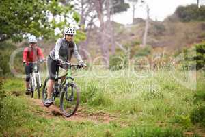 Exploring the roads less travelled. A pair of young cyclists enjoying the outdoors and keeping fit mountain biking.