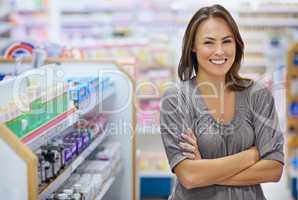 Portrait of a young woman buying medicine in a pharmacy -The commercial designs displayed in this image represent a simulation of a real product and have been changed or altered enough by our team of retouching and design specialists so that they are free