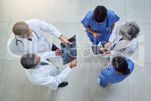 Working together to uphold their quality standard of healthcare. High angle shot of a group of medical practitioners working together in a hospital.