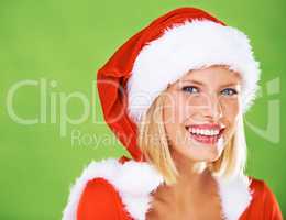 Promoting your Christmas message. Cute portrait of a happy young female modeling a red Father Christmas hat with white fur trim, isolated on green - copyspace.