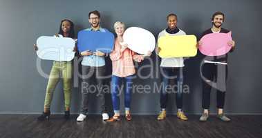 Speak your mind. Studio shot of a diverse group of people holding up speech bubbles against a gray background.