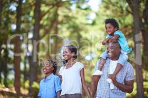 Enjoying a nature walk in the fresh air. Cute african american family spending time out in nature together.