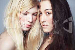 Battling with the worlds acceptance of our homsexuality. Portrait of a beautiful blonde and brunette female couple.