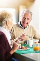 All happiness depends on a leisurely breakfast. Shot of a happy senior couple enjoying breakfast together at home.