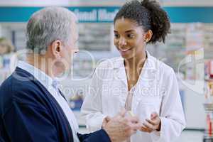 Were always ready to help you choose a healthier approach. Shot of a young pharmacist recommending a health care product to a senior citizen at a pharmacy.