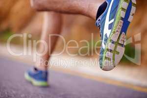 My favorite mode of transport. Low angle shot of a mans legs running along a road.