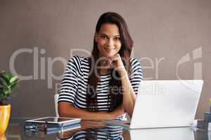Self-employed and loving it. Portrait of an attractive young businesswoman sitting at her office desk at home.