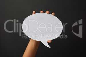 Speak your mind. Shot of a person holding a speech bubble against a dark background.