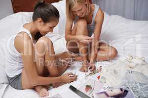 They love having sleepovers. Two young women pampering themselves at a sleepover.