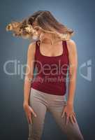 Let it all hang out. Shot of a young woman twirling her hair against a gray background.