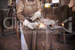 Making the magic happen. A man grinding metal in a workshop.