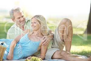 Loving moments in the open air. A smiling husband and wife enjoying a leisurely picnic in the park.