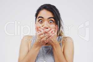 Shut the front door. Studio shot of a young woman looking shocked against a grey background.