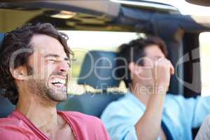 Good times with a great friend. Two friends happy and laughing together while on a drive.