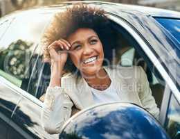 Today will be a good day. Shot of a cheerful young businesswoman driving in a car to work with her arm leaning out of the vehicle during the day.