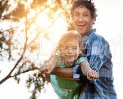 Encourage her courage. Portrait of a happy father playfully carrying his daughter during a fun day outdoors.