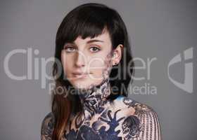 Artistic attire. A cropped studio portrait of a tattooed young woman.