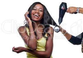 Shes going to look fabulous after this. Studio shot of an attractive young woman having her hair blow-dryed.