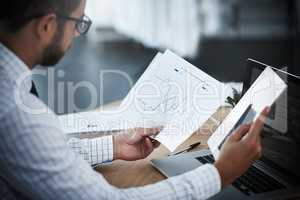 Pay close attention to what your business stats say. Shot of a young businessman using a digital tablet while analyzing graphs in an office.