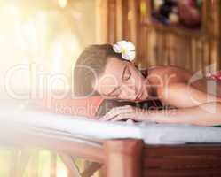 Relax and unwind. Shot of a beautiful young woman lying on a massage table at the day spa.