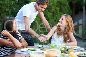 Stealing a small piece. Smiling young people at a lunch with a group of friends - portrait.