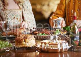 The nobility feasts while the people hunger. Cropped shot of a noble couple eating together in the palace dining room.