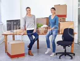 Ready for new beginnings. Full-length shot of two female entrepreneurs moving into a new office.