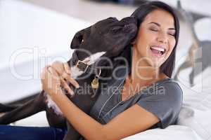 Canine companion. Shot of an attractive young woman enjoying a cuddle with her dog at home.