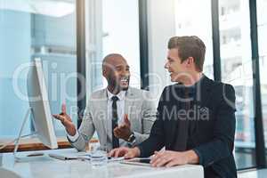 They have a great working relationship. Cropped shot of two young businessmen having a discussion while working in a modern office.